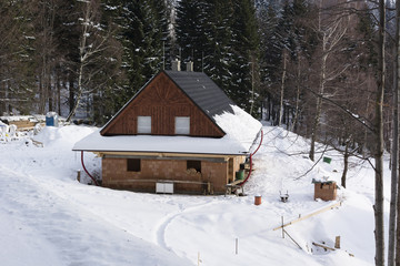 house under construction in the mountains in the snow in the woods