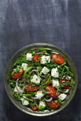 Salad with arugula, tomato, cheese and red onion