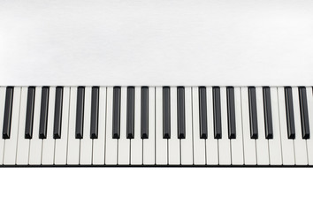 Abstract close-up of keyboard of an electronic piano in a textured metallic casing on white background