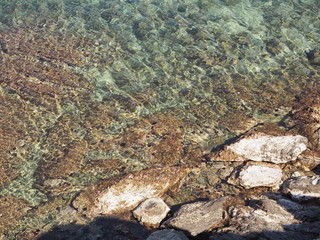 Paisaje marítimo de costa con rocas en el mar transparente, color verde, textura rugosa. 2016