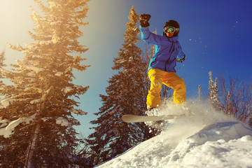 Snowboarder jumping through air with deep blue sky in background