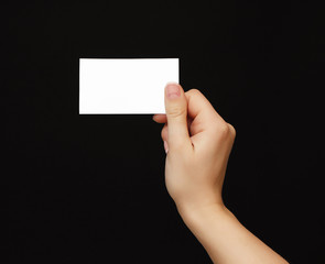 Hand hold empty blank business card isolated on black background
