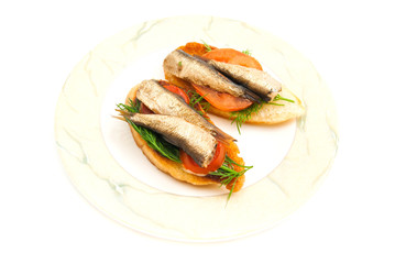 pair of sandwiches with sprats on plate