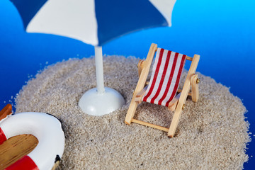 Island with toy deckchair and parasol