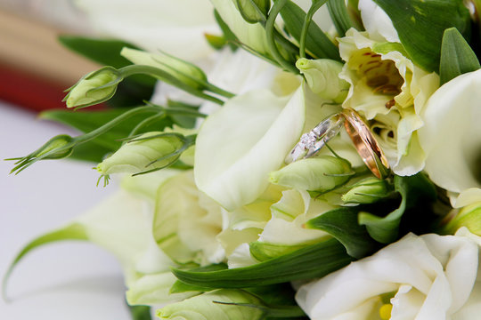 wedding rings on the bouquet of lilies and the icon