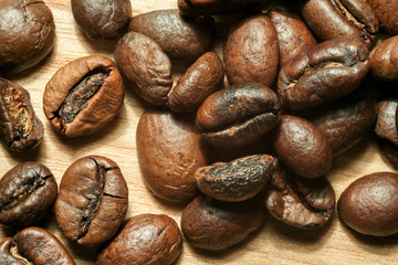 Coffee beans on beech tree background close-up