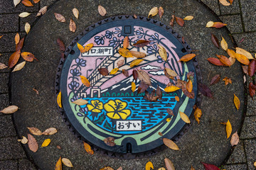 Obraz na płótnie Canvas Metal sewer manhole of Kawaguchiko lake art color street in autumn