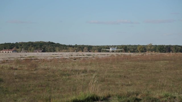Small plane is landing on an abandoned airfield.