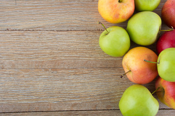 Apples colored, bright wooden background
