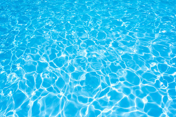 Water surface in swimming pool with sun reflection