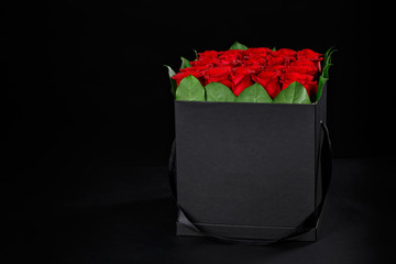Romantic red roses in a square black gift box to place the logo on a black background, studio shooting,spring is coming,international women's day,