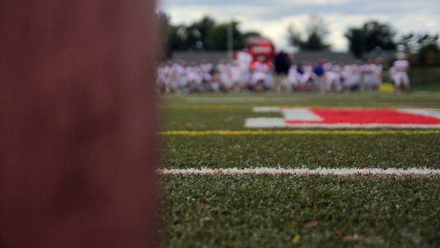 Dolly of a football stadium, as players practice in the distance.