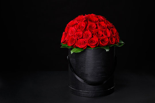 Romantic red roses in a gift textured black box to place the logo on a black background studio,spring is coming,international women's day