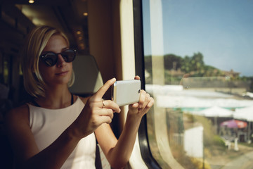 young women shooting landscape in a moving train