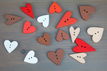 Red hearts on grey wooden background. Button love. Wooden buttons. Post card for the Valentine.