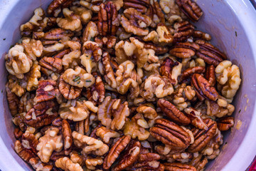 Obraz premium Mix nuts covered in butter garlic and rosemary mixture before ro