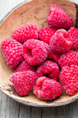 Frozen raspberries on wooden background.