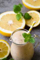 Banana and lemon smoothie, on the grey  background.
