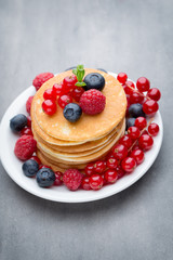 Stack of pancakes with blueberry and fresh berry.