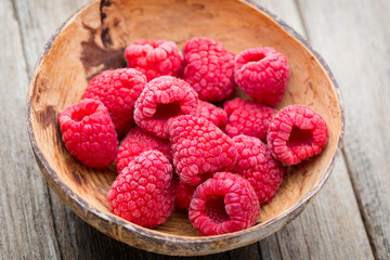 Frozen raspberries on wooden background.