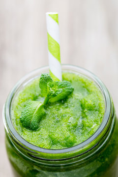 Rucola smoothie, on the grey  background.