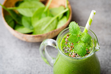 Spinach smoothie, on the grey  background.