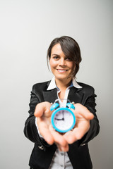 Business women holding an alarm clock in hands