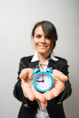 Business women holding an alarm clock in hands