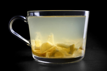 Lemon and ginger fruit tea infusion isolated on black.