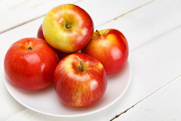 Красные яблоки на белом столе