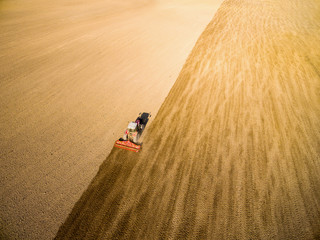 Flight over ploughed field with tractor.   Industrial background on agricultural theme. Use drones...