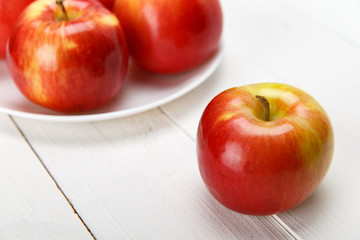 Красные яблоки на белом столе