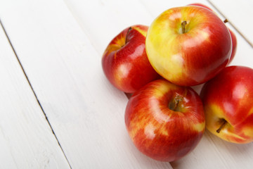 Красные яблоки на белом столе