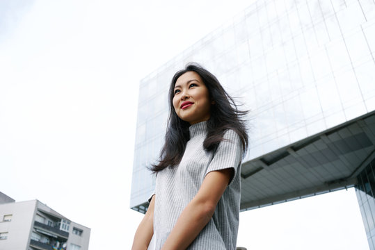 Portrait of a attractive asian business woman in front of a skyscraper