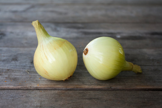 Two onion bulbs on gray old wooden table