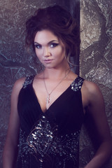 young beautiful woman in long dress against the wall,  dark style,  mysterious atmosphere