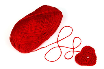 Red yarn with knitted red heart. Isolation.