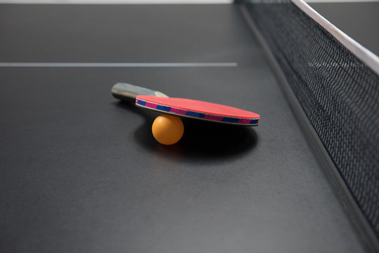 table tennis racket with orange ball