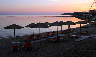Wooden umbrellas and chairs at the beach