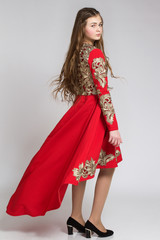 Portrait of a sensual young woman in red dress, half turned