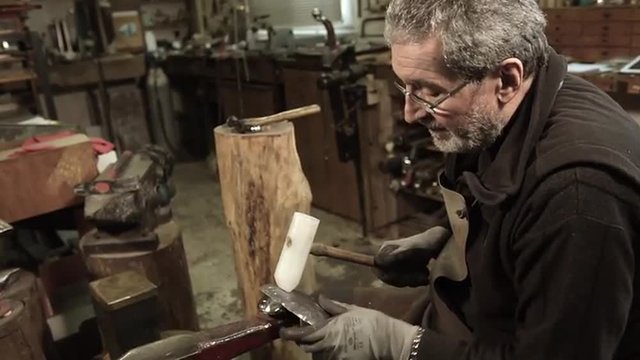 Master goldsmith working with silver-Shaping of the object by hammering