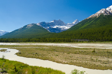 Naklejka na ściany i meble Beautiful river over majestic Rocky Mountains in Alberta, Canada.