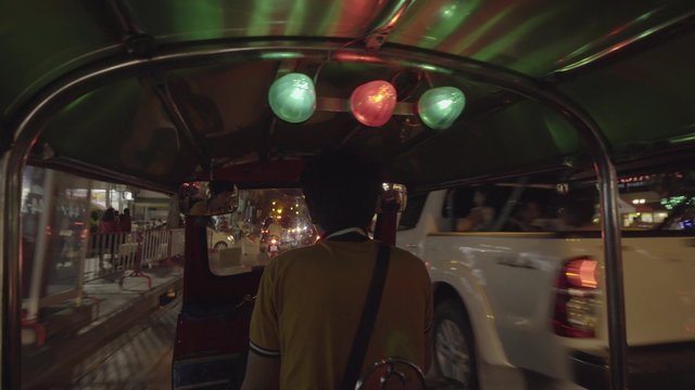 Tuktuk moving along a street in Bangkok, Thailand. Such motorbike taxis are called tuktuks in Thailand.
