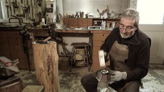 Master goldsmith working with silver-Shaping of the object by hammering