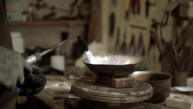 Master goldsmith working with silver-Shaping of the object by hammering