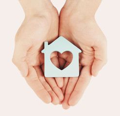 Female hands with model of house on light background