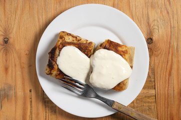 Fried pancakes with meat and sour cream