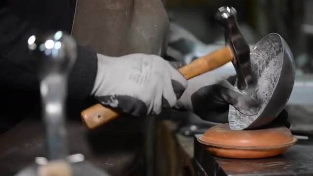 Master goldsmith working with silver-Shaping of the object by hammering