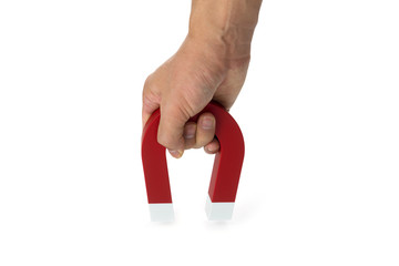 A hand holding a magnet isolated on white to pick up an object

