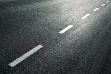 Fotobehang White dotted line on city asphalt road background. © robsonphoto